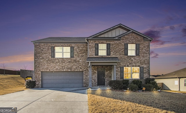 traditional-style house with an attached garage, concrete driveway, and brick siding