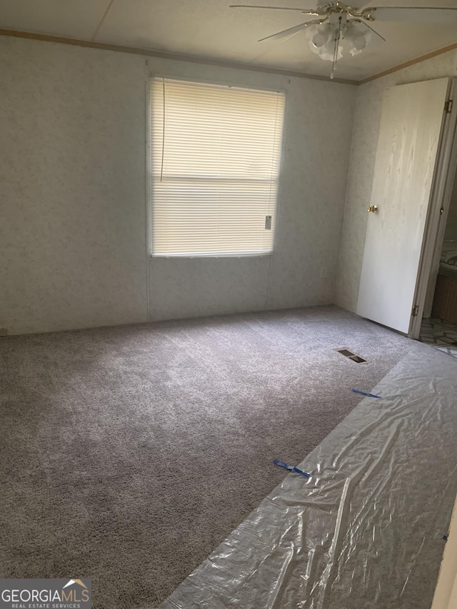 empty room featuring carpet floors and ceiling fan