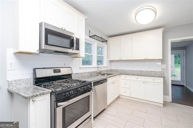 2607 Jefferson Ter, Atlanta, GA 30344 - kitchen with stainless steel appliances, light stone counters, white cabinets, and backsplash