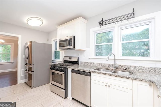 2607 Jefferson Ter, Atlanta, GA 30344 - kitchen featuring appliances with stainless steel finishes, light stone countertops, white cabinets, and light wood-style floors