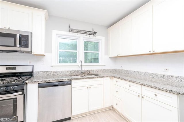 2607 Jefferson Ter, Atlanta, GA 30344 - kitchen featuring appliances with stainless steel finishes, white cabinets, tasteful backsplash, and light stone counters