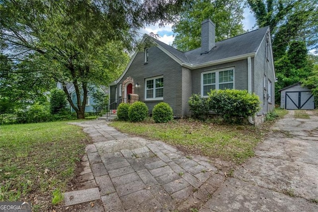 2607 Jefferson Ter, Atlanta, GA 30344 - view of front of property with a chimney, a front lawn, a detached garage, and a storage unit