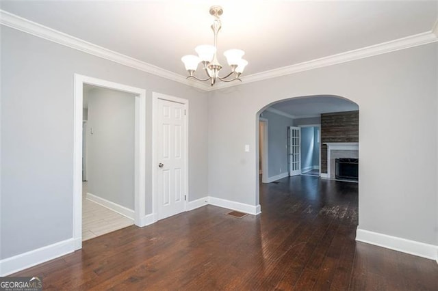 2607 Jefferson Ter, Atlanta, GA 30344 - unfurnished dining area featuring a chandelier, arched walkways, ornamental molding, hardwood / wood-style flooring, and a large fireplace