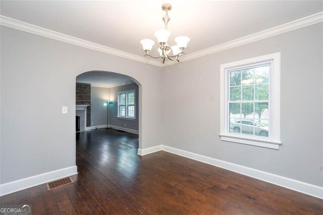 2607 Jefferson Ter, Atlanta, GA 30344 - unfurnished room with arched walkways, ornamental molding, a chandelier, hardwood / wood-style flooring, and a fireplace