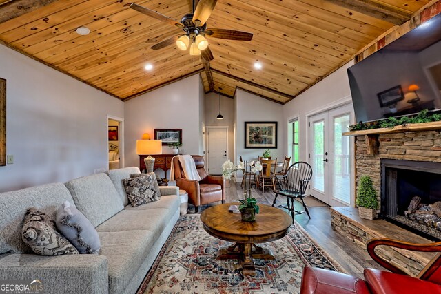 living room featuring wood ceiling, wood finished floors, lofted ceiling, ceiling fan, and a fireplace