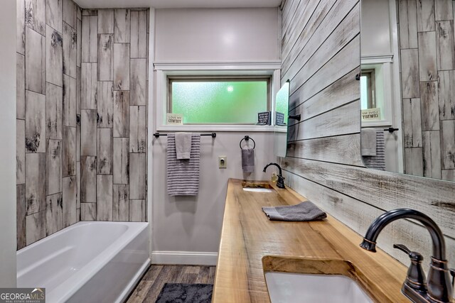 bathroom with baseboards, wood finished floors, shower / tub combination, and vanity