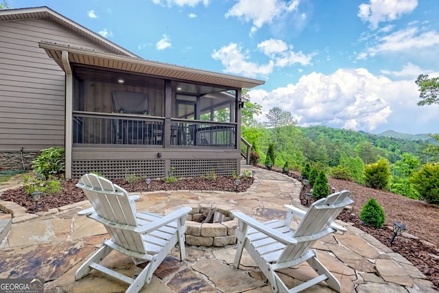 view of patio / terrace featuring a fire pit and a sunroom