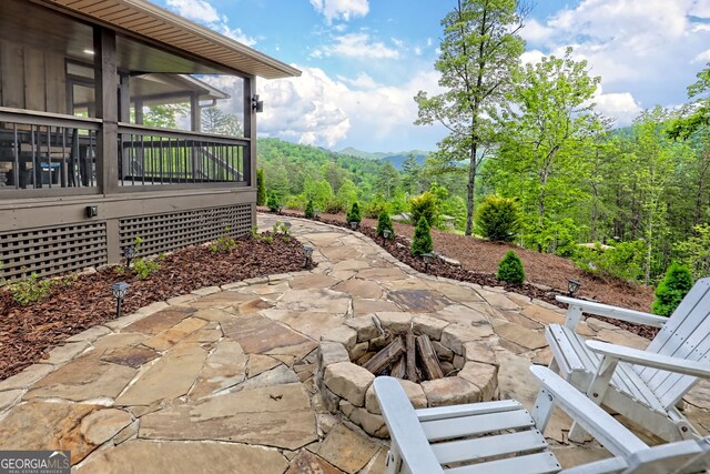 view of patio / terrace with a sunroom and a fire pit
