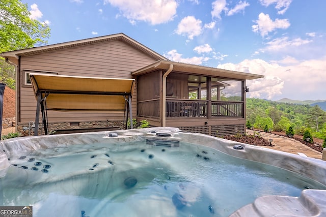 view of swimming pool with a hot tub and a sunroom
