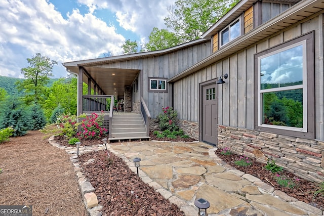 property entrance with stone siding and board and batten siding
