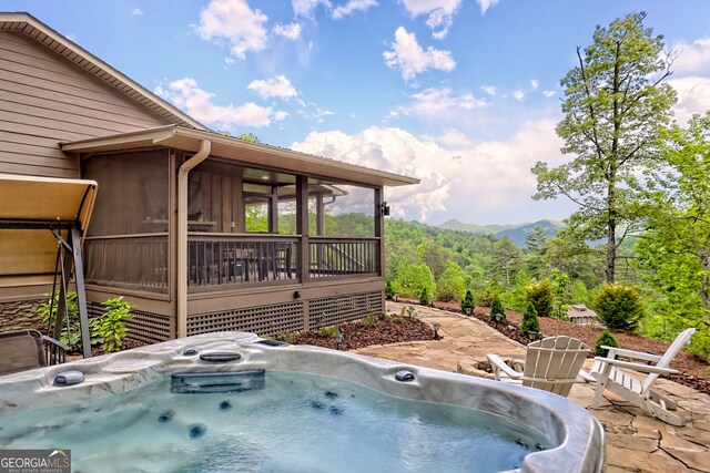 view of patio / terrace featuring a hot tub and an outdoor fire pit