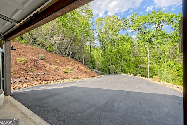 view of patio featuring driveway and a view of trees