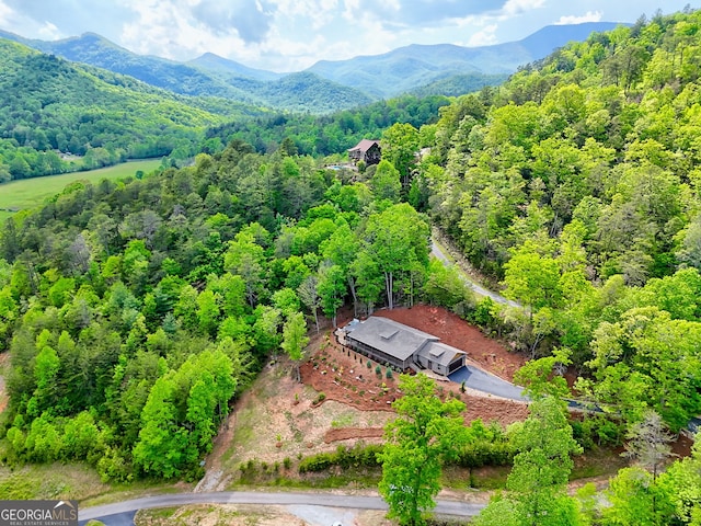view from above of property featuring a heavily wooded area and a mountainous background