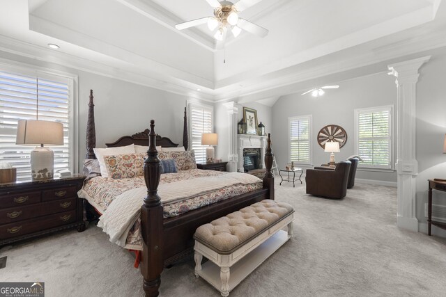 112 Pebblebrooke Run, Canton, GA 30115 - bedroom featuring a glass covered fireplace, light carpet, ornate columns, a raised ceiling, and a ceiling fan