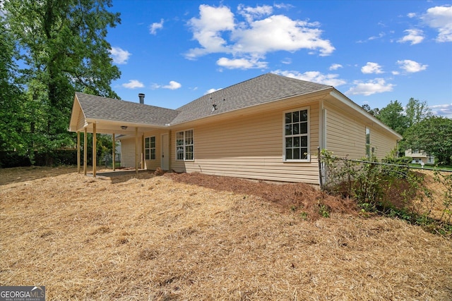 rear view of house with fence and roof with shingles