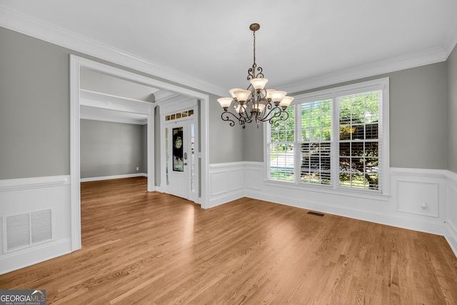 3641 Carriage Glen Way, Dacula, GA 30019 - unfurnished dining area with a chandelier, wainscoting, ornamental molding, and light wood-style floors