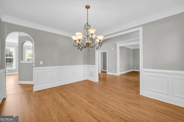 3641 Carriage Glen Way, Dacula, GA 30019 - unfurnished room featuring crown molding, light wood-type flooring, a chandelier, wainscoting, and arched walkways