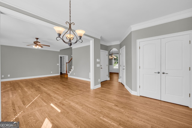 3641 Carriage Glen Way, Dacula, GA 30019 - unfurnished living room with a chandelier, a ceiling fan, crown molding, light wood finished floors, and stairway