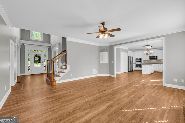 3641 Carriage Glen Way, Dacula, GA 30019 - unfurnished living room with light wood finished floors, a ceiling fan, baseboards, stairway, and a chandelier