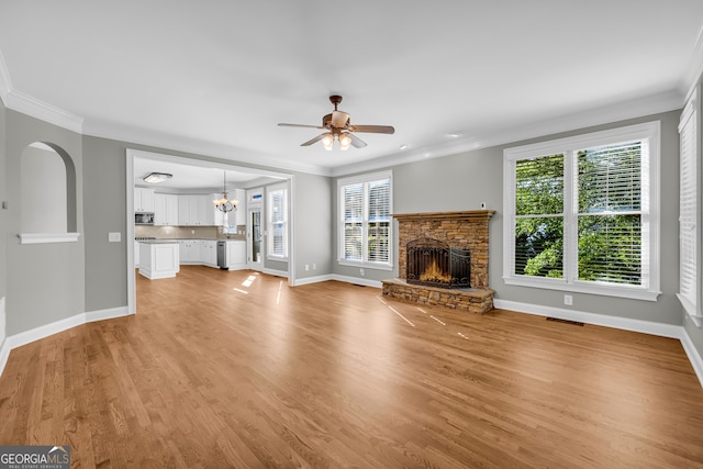 3641 Carriage Glen Way, Dacula, GA 30019 - unfurnished living room with a fireplace, crown molding, baseboards, a ceiling fan, and light wood-style flooring