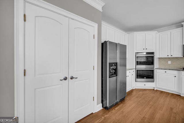 3641 Carriage Glen Way, Dacula, GA 30019 - kitchen with stainless steel appliances, wood finished floors, white cabinets, and tasteful backsplash