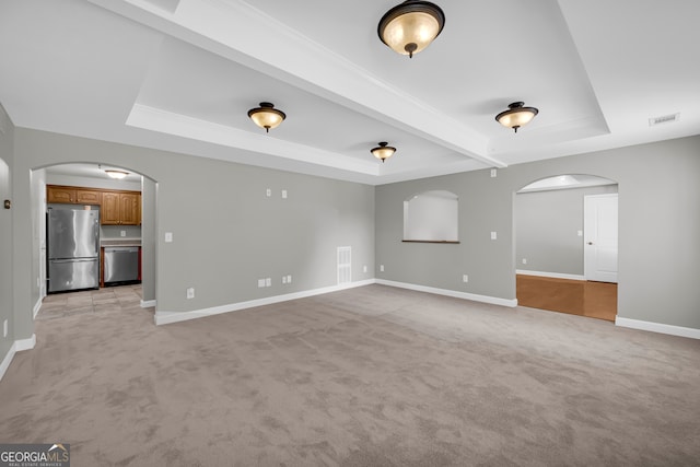 3641 Carriage Glen Way, Dacula, GA 30019 - unfurnished living room featuring arched walkways, a raised ceiling, light colored carpet, and baseboards