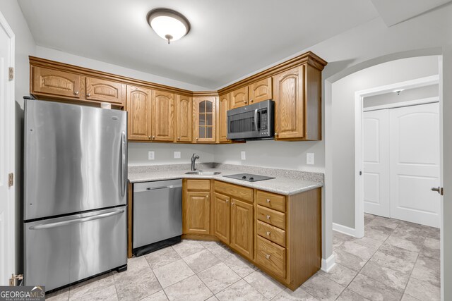3641 Carriage Glen Way, Dacula, GA 30019 - kitchen with appliances with stainless steel finishes, light countertops, a sink, glass insert cabinets, and brown cabinetry