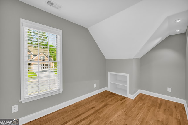 3641 Carriage Glen Way, Dacula, GA 30019 - additional living space with built in shelves, lofted ceiling, baseboards, and light wood-style floors