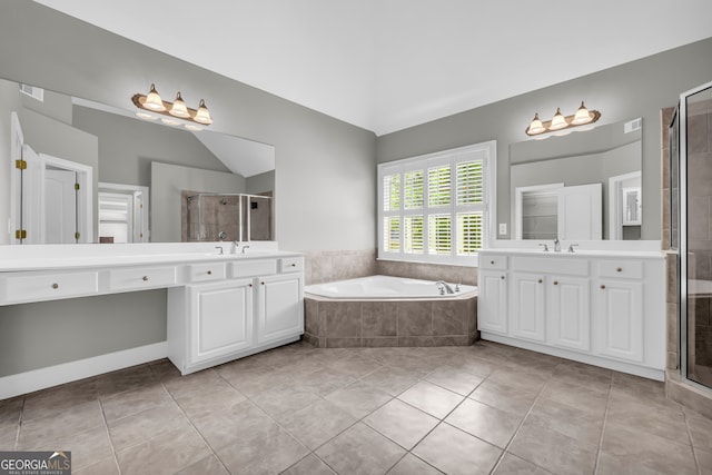 3641 Carriage Glen Way, Dacula, GA 30019 - bathroom with two vanities, lofted ceiling, a bath, a shower stall, and tile patterned floors