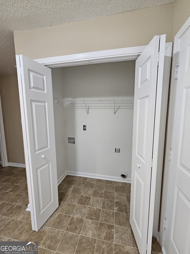 washroom featuring a textured ceiling, washer hookup, baseboards, and laundry area