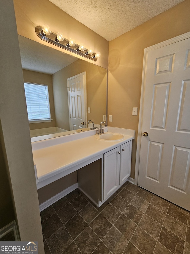 bathroom featuring a textured ceiling and vanity