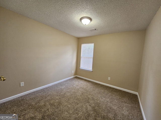 carpeted spare room with visible vents, a textured ceiling, and baseboards