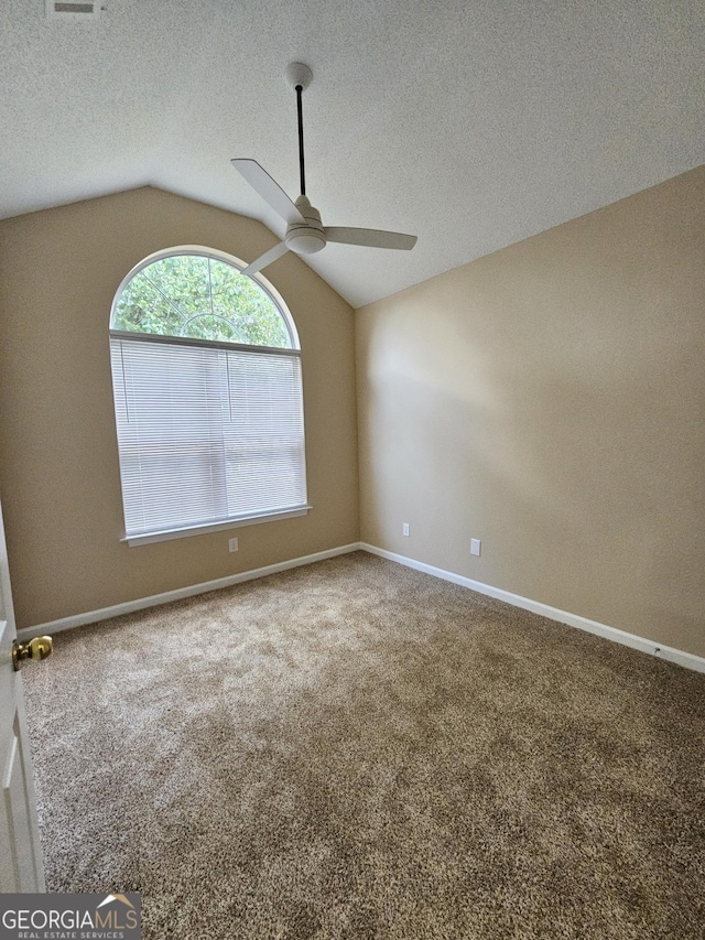 carpeted empty room with baseboards, a ceiling fan, a textured ceiling, and lofted ceiling