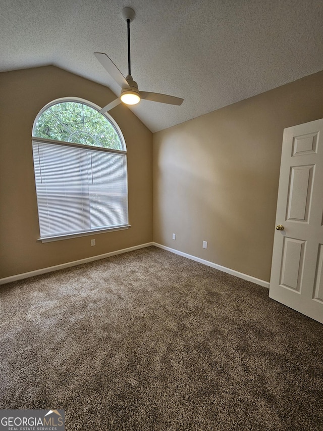 carpeted spare room featuring a ceiling fan, a textured ceiling, baseboards, and lofted ceiling