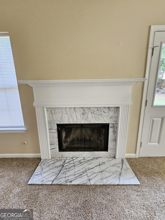room details with carpet floors, a high end fireplace, and baseboards