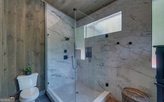 bathroom featuring toilet, a healthy amount of sunlight, and a marble finish shower