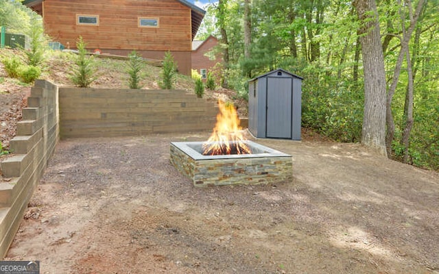 view of yard with an outbuilding, an outdoor fire pit, and a shed