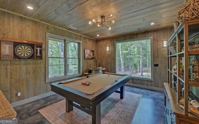 recreation room featuring wood walls, plenty of natural light, and concrete floors