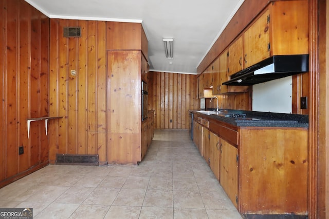 4365 US Highway 341, Jesup, GA 31545 - kitchen featuring under cabinet range hood, a sink, brown cabinetry, wooden walls, and black oven