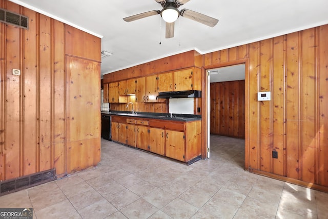 4365 US Highway 341, Jesup, GA 31545 - kitchen with under cabinet range hood, ornamental molding, wood walls, dark countertops, and brown cabinetry