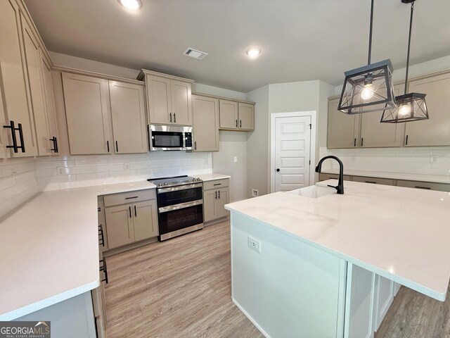 3132 Rosebud Rd Unit 1, Loganville, GA 30052 - kitchen featuring decorative backsplash, light wood-style floors, gray cabinets, a sink, and appliances with stainless steel finishes