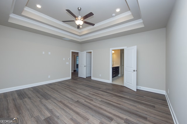 5587 Spring St, Flowery Branch, GA 30542 - unfurnished bedroom with a tray ceiling, dark wood-style flooring, recessed lighting, and connected bathroom