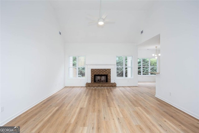 3314 Dilmus Dr, Powder Springs, GA 30127 - unfurnished living room with high vaulted ceiling, light wood-style floors, a ceiling fan, a brick fireplace, and baseboards