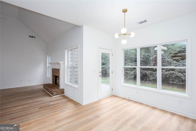 3314 Dilmus Dr, Powder Springs, GA 30127 - unfurnished living room with light wood-style flooring, a chandelier, a fireplace, baseboards, and vaulted ceiling