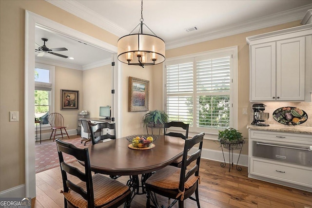 dining space with visible vents, ornamental molding, baseboards, and hardwood / wood-style floors