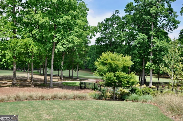view of community featuring fence and a lawn