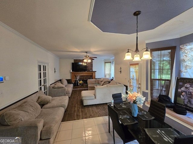 345 Oak Springs Dr NW, Lawrenceville, GA 30043 - tiled living room featuring crown molding, ceiling fan, a fireplace, and a chandelier