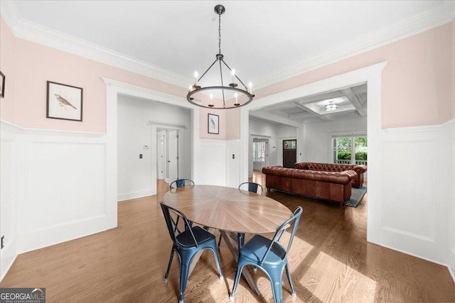 dining space featuring wood finished floors, a decorative wall, and a notable chandelier