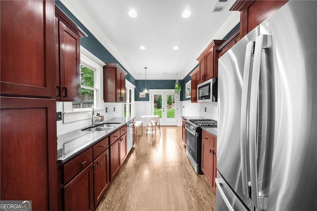 kitchen featuring french doors, ornamental molding, light wood finished floors, visible vents, and stainless steel appliances