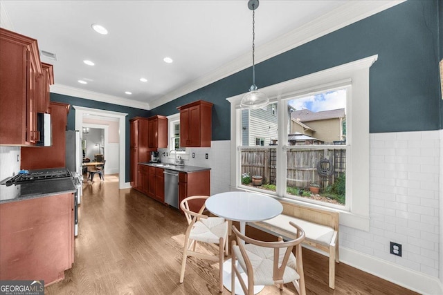 kitchen featuring a sink, dark wood-type flooring, baseboards, appliances with stainless steel finishes, and ornamental molding